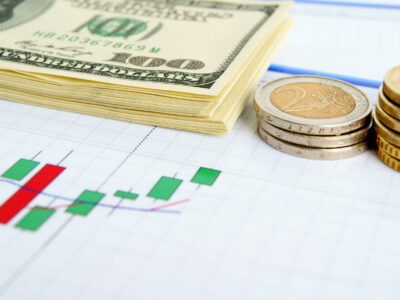 Dollar notes and euro coins on the exchange chart background