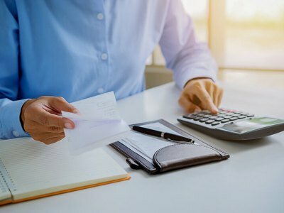 Woman with bills and calculator.