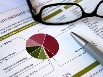 Financial concept - pie chart showing investment portfolio breakdown, glasses and pen support analysis,review theme