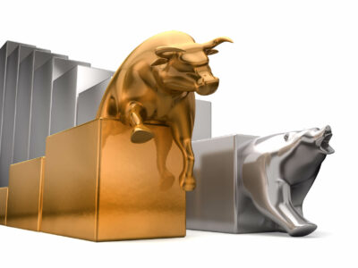 A gold bull and a platinum bear economic trends competing side by side on an isolated white background