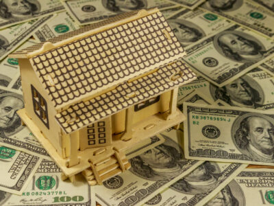 House model on background of U.S. one hundred dollar bills.