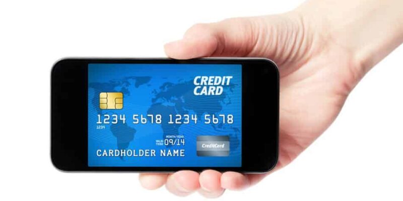 Hand holding mobile smart phone with credit card on a screen. Isolated on white.