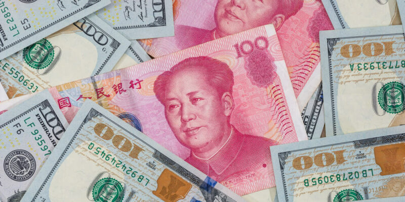 Chinese Yuan bills vs U.S. dollar as background .
