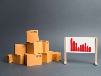 Stack of cardboard boxes and a stand with information chart. rate growth of production of goods and products, increasing economic indicators. exports or imports. Increasing consumer demand