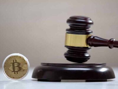 Bitcoin on table, gavel standing on sound block, crypto currency legalization