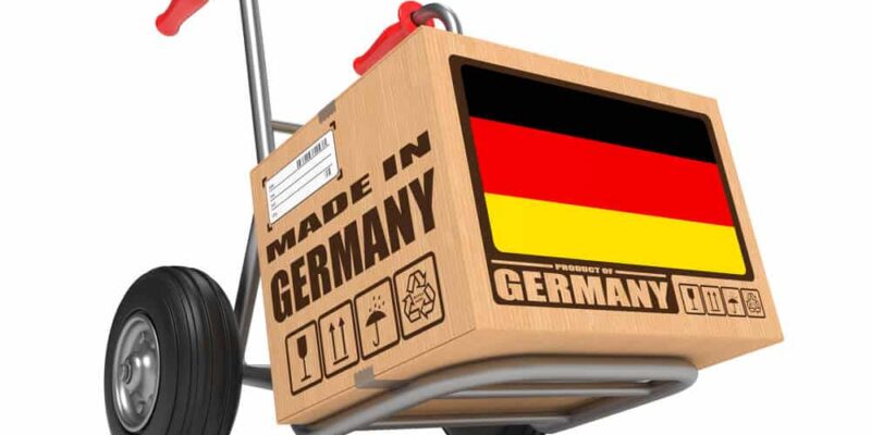 Cardboard Box with Flag of Germany and Made in Germany Slogan on Hand Truck White Background. Free Shipping Concept.