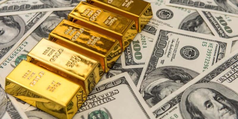 gold bars bullions lying on 100 dollar bills. wealth