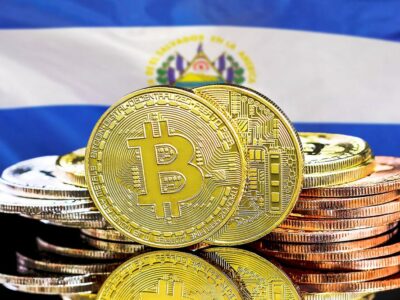 Concept for investors in cryptocurrency and Blockchain technology in El Salvador. Bitcoins on the background of the El Salvador flag
