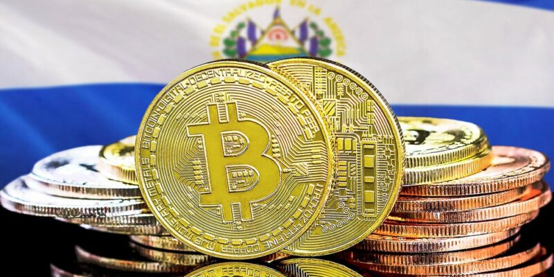 Concept for investors in cryptocurrency and Blockchain technology in El Salvador. Bitcoins on the background of the El Salvador flag