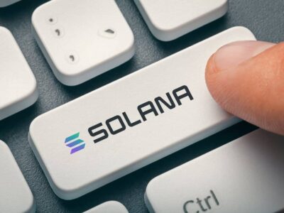 Male finger pressing computer key with Solana token logo. Cryptocurrrency mininng, trading concept.