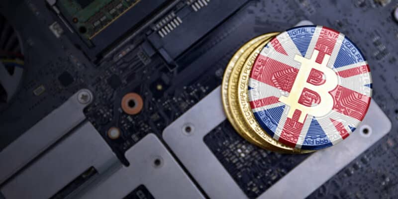 golden shining bitcoins with flag of great britain on a computer electronic circuit board. bitcoin mining concept.