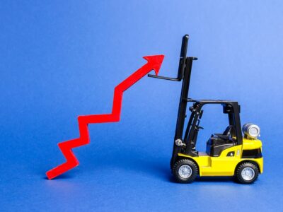 A yellow forklift raises a big red arrow up. Growth in production rates and development of industry and infrastructure. Increased sales, economy growth. Concept of increase, growth and success.