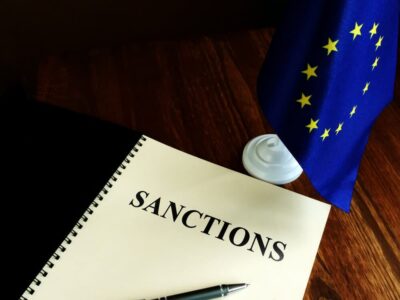 Sanctions list and EU flag on the desk.