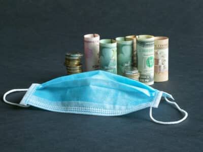 A medical mask and money. Pandemic and the economic crisis of the concept. Soft focus.