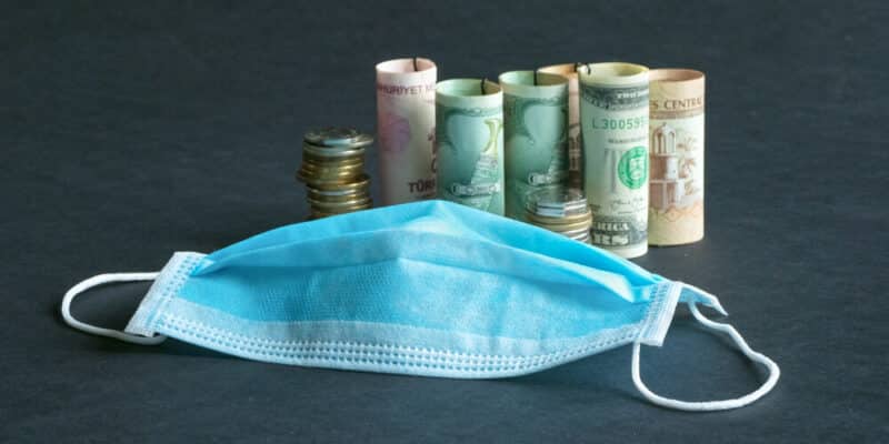 A medical mask and money. Pandemic and the economic crisis of the concept. Soft focus.