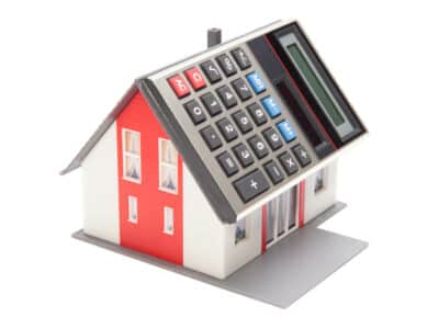 Home financing (cost of occupancy) concept - model of the house with calculator instead of the roof