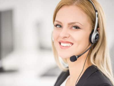 Attractive young woman in suit sitting at call center office and working.