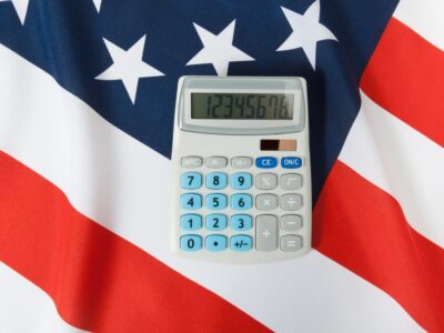 Part of studio shoot ruffled national flag with calculator over it series - United States