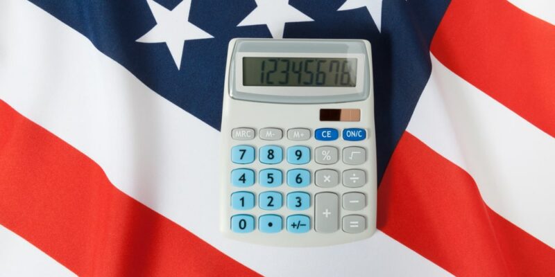Part of studio shoot ruffled national flag with calculator over it series - United States