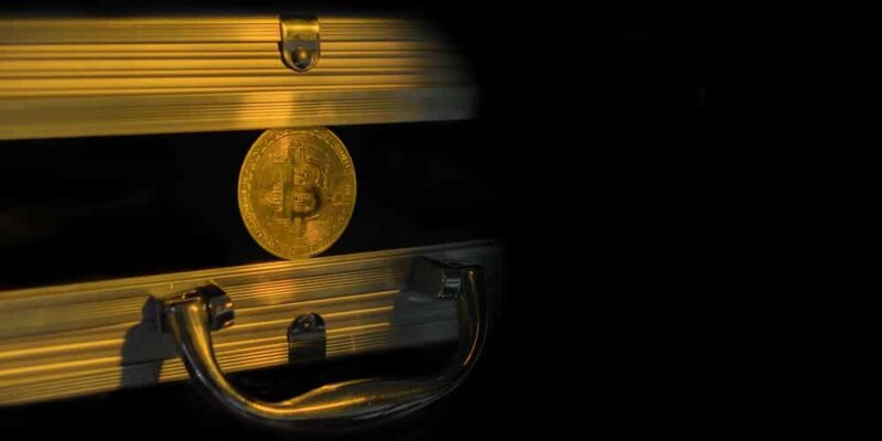 Golden bitcoin in a metal case.
