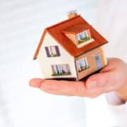 house in human hands on a white background