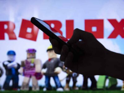 LONDON, UK - March 2021: Person holding a smartphone with Roblox game logo