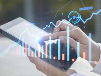 Close up of businessman hand pointing at pad on desktop with creative glowing forex chart on blurry outdoor background. Trade, device, financial investment and technology concept. Double exposure