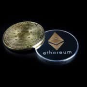 ETHEREUM (ETH) cryptocurrency; silver ethereum coin on isolated black background. CARDANO (ADA) coin. Concept coin.